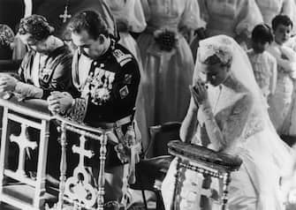 3068079 19th April 1956: Prince Rainier of Monaco with his bride, Her Most Serene Highness Princess Grace Patricia (1929 - 1982) (Grace Kelly), praying during their wedding service in Monaco Cathedral. (Photo by George W. Hales/Fox Photos/Getty Images)