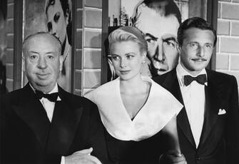 109559077 AUGUST 1: Dircetor Alfred Hitchcock, actress Grace Kelly and fashion designer Oleg Cassini attend the premiere of the movie 'Rear Window' which was released on August 1, 1954. (Photo by Frank Worth, Courtesy of Capital Art/Getty Images)