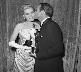 515283296 (Original Caption) Actress Grace Kelly holding her Oscar after she was honored as the "Best Actress" of 1954 at the 27th Academy Awards. She won the prize for her role in The Country Girl. Oscar-winner Kelly is kissed by Oscar winner Marlon Brando, he got an Oscar as the "Best Actor" for his role in On The Waterfront.