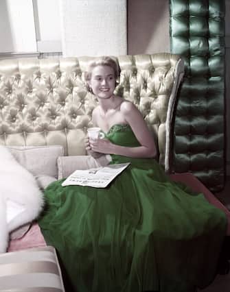 151271029 American actress Grace Kelly (1929 - 1982) wearing a green dress for St Patrick's Day, 1954. She is reading a copy of MGM's Studio News. (Photo by Gene Lester/Getty Images)