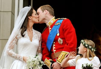113274298 LONDON - APRIL 29: TRH Prince William, Duke of Cambridge and Catherine, Duchess of Cambridge kiss on the balcony of Buckingham Palace after getting married on April 29, 2011 in London, England. The marriage of the second in line to the British throne was led by the Archbishop of Canterbury and was attended by 1900 guests, including foreign Royal family members and heads of state. Thousands of well-wishers from around the world have also flocked to London to witness the spectacle and pageantry of the Royal Wedding. (Photo by John Stillwell - WPA/Getty Images)
