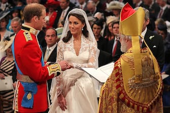 113265508 LONDON, ENGLAND - APRIL 29: Prince William exchanges rings with his bride Catherine Middleton in front of the Archbishop of Canterbury Rowan Williams inside Westminster Abbey on April 29, 2011 in London, England. The marriage of Prince William, the second in line to the British throne, to Catherine Middleton is being held in London today. The marriage of the second in line to the British throne is to be led by the Archbishop of Canterbury and will be attended by 1900 guests, including foreign Royal family members and heads of state. Thousands of well-wishers from around the world have also flocked to London to witness the spectacle and pageantry of the Royal Wedding. (Photo by Dominic Lipinski - WPA Pool/Getty Images)