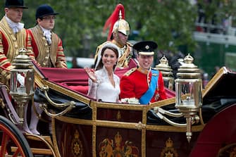 113810485 Catherine, Duchess of Cambridge and Prince William, Duke of Cambridge make the journey by carriage in procession to Buckingham Palace past crowds of spectators following their marriage at Westminster Abbey, London, 29th April 2011. The marriage of the second in line to the British throne was led by the Archbishop of Canterbury and was attended by 1900 guests, including foreign Royal family members and heads of state. Thousands of well-wishers from around the world have also flocked to London to witness the spectacle and pageantry of the Royal Wedding. (Photo by Tom Stoddart/Getty Images)