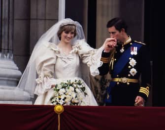 73399907 The Prince and Princess of Wales on the balcony of Buckingham Palace on their wedding day, 29th July 1981. She wears a wedding dress by David and Elizabeth Emmanuel and the Spencer family tiara. (Photo by Terry Fincher/Princess Diana Archive/Getty Images)