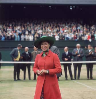 3226767 4th July 1970: Princess Margaret (1930 - 2002) on centre court at Wimbledon to present John Newcombe with the Men's Singles Trophy. (Photo by Mike Lawn/Fox Photos/Getty Images)