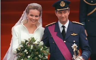 173830431 Belgium Crown Prince Philippe, 39, and Mathilde d'Udekem d'Acoz, a 26-year-old speech therapist, smile to the crowd of 2,000 wellwishers 04 December 1999 after being married in the Roman Catholic service at Saint-Michel-et-Gudule Cathedral in Brussels. Prince Philippe is first in line to succeed his father King Albert II, and the first Belgian crown prince to marry a Belgian. His own mother, Queen Paola, is Italian. Mathilde is of noble Flemish stock. She grew up in Wallon and speaks French, Dutch, English and Italian.
La princesse Mathilde d'Udekem d'Acoz et le prince Philippe de Belgique sourient au public, le 04 décembre 1999, à leur sortie de la cathédrale St Michel St Gudule de Bruxelles, après la cérémonie religieuse de leur mariage. (Photo credit should read PHILIPPE HUGUEN/AFP via Getty Images)