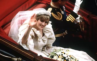 73399843 The Prince and Princess of Wales return to Buckingham Palace by carriage after their wedding, 29th July 1981. She wears a wedding dress by David and Elizabeth Emmanuel and the Spencer family tiara. (Photo by Terry Fincher/Princess Diana Archive/Getty Images)