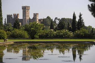 976735952 Water gardens of Sigurta Garden Park, the Scaliger Castle, 13th century, in the background, Valeggio sul Mincio, Veneto, Italy.