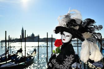 1200857959 TOPSHOT - A reveller wearing a mask and a period costume takes part in the Venice Carnival on February 15, 2020. (Photo by Alberto PIZZOLI / AFP) (Photo by ALBERTO PIZZOLI/AFP via Getty Images)