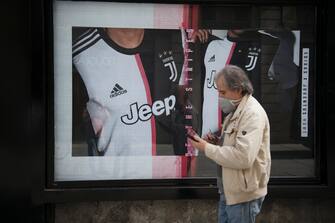 TURIN, ITALY - MAY 18: A man with a protective mask walks near a window of the Juventus clothing store which has reopened after more than two months of lockdown on May 18, 2020 in Turin, Italy. Restaurants, bars, cafes, hairdressers and other shops have reopened, subject to social distancing measures, after more than two months of a nationwide lockdown meant to curb the spread of Covid-19. (Photo by Stefano Guidi/Getty Images)