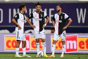 Juventus' Portuguese forward Cristiano Ronaldo (C) stands between Juventus' Argentine forward Paulo Dybala (L) and Juventus' Bosnian midfielder Miralem Pjanic prior to shooting a free kick during the Italian Serie A football match Bologna vs Juventus on June 22, 2020 at the Renato-Dall'Ara stadium in Bologna, as the country eases its lockdown aimed at curbing the spread of the COVID-19 infection, caused by the novel coronavirus. (Photo by Miguel MEDINA / AFP) (Photo by MIGUEL MEDINA/AFP via Getty Images)