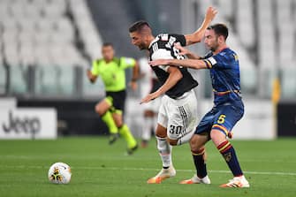 TURIN, ITALY - JUNE 26:  Rodrigo Bentancur of Juventus is tackled by Fabio Lucioni of US Lecce during the Serie A match between Juventus and  US Lecce at Allianz Stadium on June 26, 2020 in Turin, Italy.  (Photo by Valerio Pennicino/Getty Images)