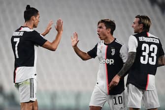 Juventus' Argentine forward Paulo Dybala (C) celebrates with Juventus' Portuguese forward Cristiano Ronaldo (L) and Juventus' Italian forward Federico Bernardeschi after opening the scoring during the Italian Serie A football match Juventus vs Lecce played on June 26, 2020 behind closed doors at the Juventus stadium in Turin, as the country eases its lockdown aimed at curbing the spread of the COVID-19 infection, caused by the novel coronavirus. (Photo by Miguel MEDINA / AFP) (Photo by MIGUEL MEDINA/AFP via Getty Images)