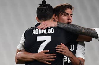 Juventus' Argentine forward Paulo Dybala (R) celebrates with Juventus' Portuguese forward Cristiano Ronaldo after opening the scoring during the Italian Serie A football match Juventus vs Lecce played on June 26, 2020 behind closed doors at the Juventus stadium in Turin, as the country eases its lockdown aimed at curbing the spread of the COVID-19 infection, caused by the novel coronavirus. (Photo by Miguel MEDINA / AFP) (Photo by MIGUEL MEDINA/AFP via Getty Images)