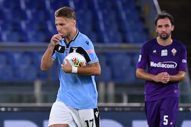 Lazio's Italian forward Ciro Immobile (L) reacts after scoring a penalty during the Italian Serie A football match Lazio vs Fiorentina played on June 27, 2020 behind closed doors at the Olympic stadium in Rome, as the country eases its lockdown aimed at curbing the spread of the COVID-19 infection, caused by the novel coronavirus. (Photo by Alberto PIZZOLI / AFP) (Photo by ALBERTO PIZZOLI/AFP via Getty Images)