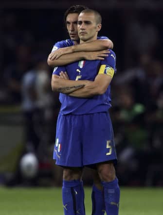BERLIN - JULY 09:  Fabio Cannavaro (R) of Italy is hugged by teammate, Andrea Pirlo, as they watch the penalty shoot out during the FIFA World Cup Germany 2006 Final match between Italy and France at the Olympic Stadium on July 9, 2006 in Berlin, Germany.
  (Photo by Ben Radford/Getty Images)