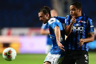 Napoli's Portuguese defender Mario Rui (L) holds off Atalanta's Colombian forward Luis Muriel during the Italian Serie A football match Atalanta vs Napoli played on July 2, 2020 behind closed doors at the Atleti Azzurri d'Italia stadium in Bergamo, as the country eases its lockdown aimed at curbing the spread of the COVID-19 infection, caused by the novel coronavirus. (Photo by Miguel MEDINA / AFP) (Photo by MIGUEL MEDINA/AFP via Getty Images)