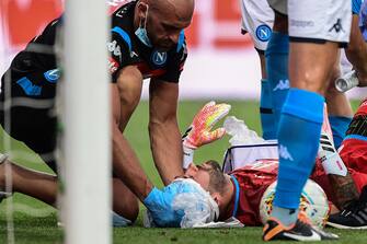 A staff medic tends to Napoli's Colombian goalkeeper David Ospina after he collided with Atalanta's Italian defender Mattia Caldara during the Italian Serie A football match Atalanta vs Napoli played on July 2, 2020 behind closed doors at the Atleti Azzurri d'Italia stadium in Bergamo, as the country eases its lockdown aimed at curbing the spread of the COVID-19 infection, caused by the novel coronavirus. (Photo by Miguel MEDINA / AFP) (Photo by MIGUEL MEDINA/AFP via Getty Images)