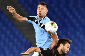 Lazio's Spanish defender Patric (L) and AC Milan's Turkish forward Hakan Calhanoglu go for a header during the Italian Serie A football match Lazio vs AC Milan played behind closed doors on July 4, 2020 at the Olympic stadium in Rome, as the country eases its lockdown aimed at curbing the spread of the COVID-19 infection, caused by the novel coronavirus. (Photo by Tiziana FABI / AFP) (Photo by TIZIANA FABI/AFP via Getty Images)