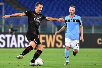 AC Milan's Swedish forward Zlatan Ibrahimovic (L) challenges Lazio's Italian midfielder Manuel Lazzari during the Italian Serie A football match Lazio vs AC Milan played behind closed doors on July 4, 2020 at the Olympic stadium in Rome, as the country eases its lockdown aimed at curbing the spread of the COVID-19 infection, caused by the novel coronavirus. (Photo by Tiziana FABI / AFP) (Photo by TIZIANA FABI/AFP via Getty Images)