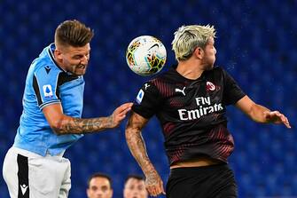 Lazio's Italian defender Francesco Acerbi (L) and AC Milan's French defender Theo Hernandez go for a header during the Italian Serie A football match Lazio vs AC Milan played behind closed doors on July 4, 2020 at the Olympic stadium in Rome, as the country eases its lockdown aimed at curbing the spread of the COVID-19 infection, caused by the novel coronavirus. (Photo by Tiziana FABI / AFP) (Photo by TIZIANA FABI/AFP via Getty Images)