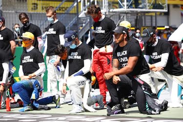 SPIELBERG, AUSTRIA - JULY 05: Lewis Hamilton of Great Britain and Mercedes GP, Pierre Gasly of France and Scuderia AlphaTauri  and some of the F1 drivers take a knee on the grid in support of the Black Lives Matter movement ahead of the Formula One Grand Prix of Austria at Red Bull Ring on July 05, 2020 in Spielberg, Austria. (Photo by Mark Thompson/Getty Images)