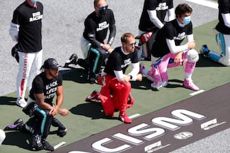 SPIELBERG, AUSTRIA - JULY 05: Sebastian Vettel of Germany and Ferrari, Lewis Hamilton of Great Britain and Mercedes GP and Lance Stroll of Canada and Racing Point take a knee in support of the 'Black Lives Matter' movement during the Formula One Grand Prix of Austria at Red Bull Ring on July 05, 2020 in Spielberg, Austria. (Photo by Peter Fox/Getty Images)
