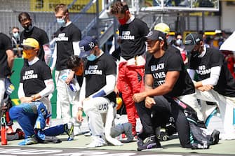 Drivers and team members including Mercedes' British driver Lewis Hamilton (R) take a knee against racism  prior to the Austrian Formula One Grand Prix race on July 5, 2020 in Spielberg, Austria. (Photo by Mark Thompson / various sources / AFP) (Photo by MARK THOMPSON/POOL/AFP via Getty Images)