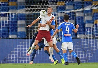 NAPLES, ITALY - JULY 05: Edin Dzeko of AS Roma vies with Kostantinos Manolas and Diego Demme of SSC Napoli during the Serie A match between SSC Napoli and  AS Roma at Stadio San Paolo on July 05, 2020 in Naples, Italy. (Photo by Francesco Pecoraro/Getty Images)