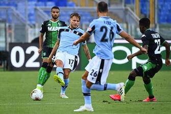 Lazio's Italian forward Ciro Immobile (2ndL) passes the  ball to Lazio's Romanian defender Stefan Radu during the Italian Serie A football match Lazio Rome vs Sassuolo played behind closed doors on July 11, 2020 at the Olympic stadium in Rome, as the country eases its lockdown aimed at curbing the spread of the COVID-19 infection, caused by the novel coronavirus. (Photo by Vincenzo PINTO / AFP) (Photo by VINCENZO PINTO/AFP via Getty Images)