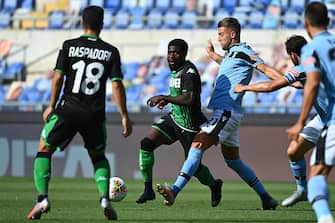 Sassuolo's Ivorian forward Jeremie Boga (C) outruns Lazio's Serbian midfielder Sergej Milinkovic-Savic during the Italian Serie A football match Lazio Rome vs Sassuolo played behind closed doors on July 11, 2020 at the Olympic stadium in Rome, as the country eases its lockdown aimed at curbing the spread of the COVID-19 infection, caused by the novel coronavirus. (Photo by Vincenzo PINTO / AFP) (Photo by VINCENZO PINTO/AFP via Getty Images)