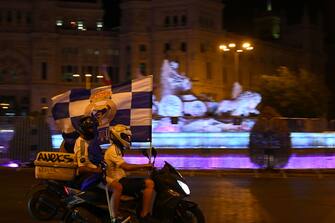 Real MadridÂ´s fans celebrate waving a flag on a bike at Cibeles square after Real Madrid won the Liga title on July 16, 2020 in Madrid. (Photo by GABRIEL BOUYS / AFP) (Photo by GABRIEL BOUYS/AFP via Getty Images)