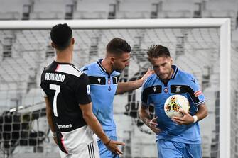 Lazio's Italian forward Ciro Immobile (R) celebrates with teammates, next to Juventus' Portuguese forward Cristiano Ronaldo reacting, after scoring a goal during the Italian Serie A football match between Juventus and Lazio, on July 20, 2020 at the Allianz stadium, in Turin, northern Italy. (Photo by Marco BERTORELLO / AFP) (Photo by MARCO BERTORELLO/AFP via Getty Images)