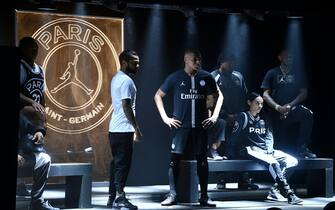Paris Saint-Germain's Brazilian defender Dani Alves (L) and French forward Kylian MBappe (R) pose with the club's UEFA Champions League new jerseys at the Parc des Princes stadium in Paris on September 13, 2018. - Those white and black jerseys are made with the Jordan Brand, created by Basketball legend Michael Jordan in partnership with Nike. (Photo by FRANCK FIFE / AFP)        (Photo credit should read FRANCK FIFE/AFP via Getty Images)