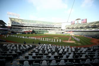OAKLAND, CALIFORNIA - JULY 24:  The Los Angeles Angels and the Oakland Athletics stand and kneel during the National Anthem before their opening day game at Oakland-Alameda County Coliseum on July 24, 2020 in Oakland, California. The 2020 season had been postponed since March due to the COVID-19 pandemic. (Photo by Ezra Shaw/Getty Images)