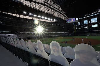 ARLINGTON, TEXAS - JULY 24:  Cardboard cut-out images of fans are seen as the sun sets in the third inning of play between the Colorado Rockies and the Texas Rangers on Opening Day at Globe Life Field on July 24, 2020 in Arlington, Texas.  The 2020 season had been postponed since March due to the COVID-19 pandemic.   (Photo by Ronald Martinez/Getty Images)