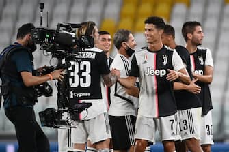 Juventus' team celebrates the Serie A title (scudetto) with Juventus' midfielder Federico Bernardeschi (2L) after the Italian Serie A football match between Juventus and Sampdoria played behind closed doors at the Allianz Stadium in Turin on July 26, 2020. - Juventus claimed a ninth Serie A title in a row on July 26 following a 2-0 win over Sampdoria. (Photo by MARCO BERTORELLO / AFP) (Photo by MARCO BERTORELLO/AFP via Getty Images)