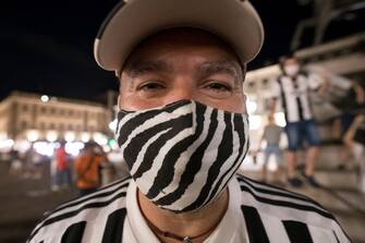TURIN, ITALY - JULY 26: A Juventus FC fan wearing a protective mask celebrates the team's Serie A victory over UC Sampdoria on July 26, 2020 in Turin, Italy. Fans gathered to celebrate the team's ninth consecutive Scudetto. (Photo by Stefano Guidi/Getty Images)