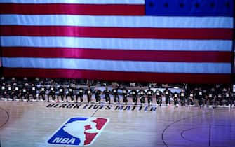 LAKE BUENA VISTA, FL - JULY 31: Players kneel behind a Black Lives Matter court decal before the start of a game between the Brooklyn Nets and the Orlando Magic on July 31, 2020 at The HP Field House at ESPN Wide World Of Sports Complex in Lake Buena Vista, Florida. NOTE TO USER: User expressly acknowledges and agrees that, by downloading and/or using this Photograph, user is consenting to the terms and conditions of the Getty Images License Agreement. (Photo by Ashley Landis - Pool/Getty Images)