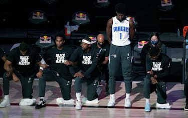 LAKE BUENA VISTA, FL - JULY 31: Jonathan Isaac #1 of the Orlando Magic stands as others kneel before the start of a game between the Brooklyn Nets and the Orlando Magic on July 31, 2020 at The HP Field House at ESPN Wide World Of Sports Complex in Lake Buena Vista, Florida. NOTE TO USER: User expressly acknowledges and agrees that, by downloading and/or using this Photograph, user is consenting to the terms and conditions of the Getty Images License Agreement. (Photo by Ashley Landis - Pool/Getty Images)