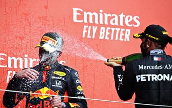 NORTHAMPTON, ENGLAND - AUGUST 09: Race winner Max Verstappen of Netherlands and Red Bull Racing and second placed Lewis Hamilton of Great Britain and Mercedes GP celebrate on the podium  during the F1 70th Anniversary Grand Prix at Silverstone on August 09, 2020 in Northampton, England. (Photo by Mark Thompson/Getty Images)