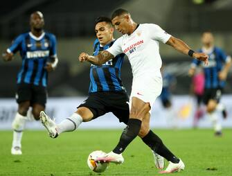 epa08616980 Lautaro Martinez (L) of Inter in action against Diego Carlos of Sevilla during the UEFA Europa League final match between Sevilla FC and Inter Milan in Cologne, Germany 21 August 2020.  EPA/Lars Baron / POOL
