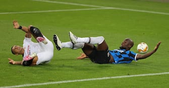 epa08616913 Romelu Lukaku (R) of Inter falls to the pitch after a foul by Diego Carlos of Sevilla during the UEFA Europa League final match between Sevilla FC and Inter Milan in Cologne, Germany 21 August 2020.  EPA/Friedemann Vogel / POOL