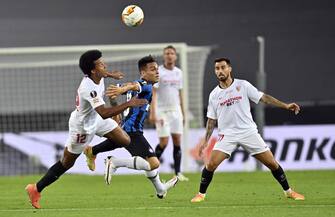 epa08616988 Lautaro Martinez of Inter (C) in action against Jules Kounde (L) of Sevilla during the UEFA Europa League final match between Sevilla FC and Inter Milan in Cologne, Germany 21 August 2020.  EPA/Martin Meissner / POOL