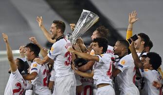 epa08617368 Players of Sevilla celebrate with the trophy after winning the UEFA Europa League final match between Sevilla FC and Inter Milan in Cologne, Germany 21 August 2020.  EPA/Martin Meissner / POOL