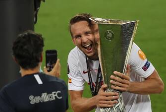 epa08617355 Luuk de Jong of Sevilla poses with the trophy after winning the UEFA Europa League final match between Sevilla FC and Inter Milan in Cologne, Germany 21 August 2020.  EPA/Lars Baron / POOL