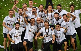 epa08617475 Sevilla coach Julen Lopetegui (bottom C) and his coaching team pose witt the trophy after winning the UEFA Europa League final match between Sevilla FC and Inter Milan in Cologne, Germany 21 August 2020. Sevilla won 3-2.  EPA/Ina Fassbender / POOL