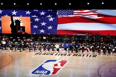 epaselect epa08623202 Members of the Orlando Magic and the Milwaukee Bucks take a knee during the national anthem before their NBA basketball first-round playoff game four at the ESPN Wide World of Sports Complex in Kissimmee, Florida, USA, 24 August 2020.  EPA/JOHN G. MABANGLO SHUTTERSTOCK OUT