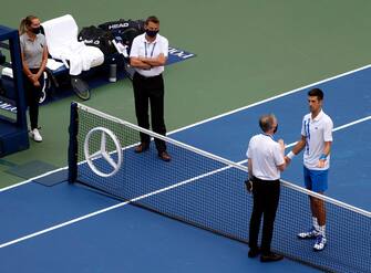 epa08651693 Head of Officiating at International Tennis Federation (ITF) Soeren Friemel (L) talks to Novak Djokovic of Serbia (R) after he accidentally hit a linesperson with a ball in the throat during his match against Pablo Carreno Busta of Spain on the seventh day of the US Open Tennis Championships at the USTA National Tennis Center in Flushing Meadows, New York, USA, 06 September 2020. Djokovic was defaulted from tournament. Due to the coronavirus pandemic, the US Open is being played without fans and runs from 31 August through 13 September.  EPA/JASON SZENES