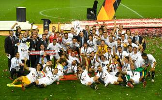 COLOGNE, GERMANY - AUGUST 21: Players and staff of Sevilla FC celebrate with the UEFA Europa League Trophy following victory in the UEFA Europa League Final between Seville and FC Internazionale at RheinEnergieStadion on August 21, 2020 in Cologne, Germany. (Photo by Ina Fassbender/Pool via Getty Images)